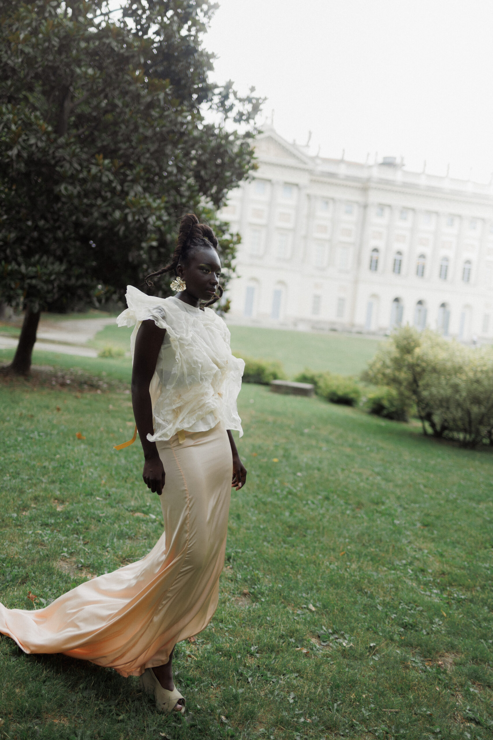 Team and models in Milan gardens during a Jadis photoshoot, showcasing the Goccia D’anima collection by Manuela Geri.